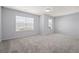 A spacious bedroom features neutral carpet, light gray walls, and natural light from two windows at 3845 Alden Place, Cumming, GA 30028