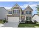 Charming two-story home with a well-manicured lawn, two-car garage, and traditional architectural details at 3845 Alden Place, Cumming, GA 30028