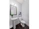 Stylish powder room featuring a pedestal sink, dark wood floors, decorative mirror and gray walls at 3845 Alden Place, Cumming, GA 30028