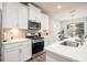 Bright kitchen featuring stainless steel appliances, white cabinets and countertops, and modern fixtures at 126 Maple Creek Way, Woodstock, GA 30188