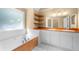 Bathroom with double sinks, wooden shelves, a soaking tub, and a tiled floor at 2242 Longford Ne Ct, Marietta, GA 30066
