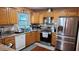 Bright kitchen with stainless steel appliances, wooden cabinets, and a sink next to a window at 3129 Rock Pine Way, Snellville, GA 30078