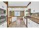 Well-lit kitchen with white cabinets, stainless steel oven, wooden accents, tile floors, and views into an adjacent room at 2107 Old Dallas Sw Rd, Marietta, GA 30064