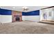 Spacious living room featuring a brick fireplace, blue accent wall, carpeted floor, and a doorway at 2107 Old Dallas Sw Rd, Marietta, GA 30064