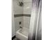 Clean bathroom with white tile, a tub, shower head, and a decorative shower curtain at 1074 Hobson Sw St, Atlanta, GA 30310