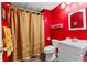 Compact, red bathroom with a vanity, toilet, and shower with a striped curtain at 238 Chappell Rd, Fayetteville, GA 30215