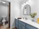 Bathroom featuring a vanity with blue cabinets, white countertop, and an arched mirror at 238 Chappell Rd, Fayetteville, GA 30215