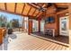 A covered porch with a wooden deck, ceiling fans, an outdoor kitchen, and brick walls at 238 Chappell Rd, Fayetteville, GA 30215