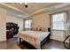 Spacious bedroom featuring a tray ceiling, dark hardwood floors, and large windows for natural light at 3030 Appling Hills Dr, Dacula, GA 30019