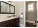 Elegant powder room features dark wood vanity, marble countertop, and stylish mirror at 5175 Wilshire Xing, Cumming, GA 30040