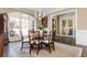 Elegant dining area with a round table set, bathed in natural light from large windows, and adjacent to french doors at 5175 Wilshire Xing, Cumming, GA 30040