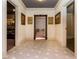 Hallway with gray tile floors, art, and access to a wine rack room and media room at 5175 Wilshire Xing, Cumming, GA 30040