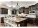 Kitchen island with stone countertop and modern pendant lights highlighting custom dark wood cabinetry at 5175 Wilshire Xing, Cumming, GA 30040