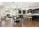 Open floor plan featuring a kitchen with dark wood cabinets and a large island open to a living room with fireplace at 5175 Wilshire Xing, Cumming, GA 30040