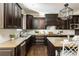 Kitchen featuring dark cabinets, stone countertops, stainless steel appliances, and modern tile backsplash at 5175 Wilshire Xing, Cumming, GA 30040