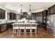 A large kitchen island with stone countertop and modern pendant lights highlighting custom dark wood cabinetry at 5175 Wilshire Xing, Cumming, GA 30040