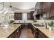 Kitchen featuring dark cabinets, stone countertops, and stainless steel appliances open to the living space at 5175 Wilshire Xing, Cumming, GA 30040