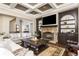 Spacious living room featuring a stone fireplace, coffered ceilings, and open-concept design at 5175 Wilshire Xing, Cumming, GA 30040