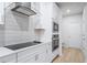 Close up of a sleek kitchen with stainless steel appliances, tile backsplash, and white cabinets at 1068 Rose Dr, Marietta, GA 30060