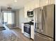 Modern kitchen featuring stainless steel appliances, granite countertops, and wood flooring at 110 Roberts Rd, Suwanee, GA 30024