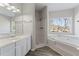 Bright bathroom featuring a bathtub, a shower, a window, and an undermount sink at 1295 Brady Ct, Hampton, GA 30228