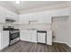 Clean kitchen featuring white cabinets, modern appliances, and laminate wood floors at 1295 Brady Ct, Hampton, GA 30228