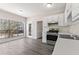 Clean kitchen featuring white cabinets, modern appliances, and laminate wood floors, with lots of natural light at 1295 Brady Ct, Hampton, GA 30228