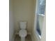 Compact bathroom showcasing a standard white toilet next to a window at 2615 Fox Hall Ln, Atlanta, GA 30349