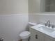 Well-lit bathroom featuring a modern toilet and sink with white cabinets and wainscotting at 2615 Fox Hall Ln, Atlanta, GA 30349