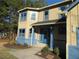 Charming two-story home with blue trim, a front porch, and neatly landscaped garden beds at 2615 Fox Hall Ln, Atlanta, GA 30349