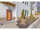 Inviting front entrance with an orange door, white siding, stone accents, and manicured landscaping at 488 Hammons Way, Atlanta, GA 30315