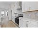 Close-up of gourmet kitchen with white countertops, stainless steel appliances, and white cabinetry at 488 Hammons Way, Atlanta, GA 30315