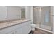 Primary bathroom featuring double sink vanity with granite countertop and tiled walk-in shower at 8662 Webb Rd, Riverdale, GA 30274