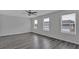 Spacious living room featuring luxury vinyl flooring, a ceiling fan, and large windows providing natural light at 8666 Webb Rd, Riverdale, GA 30274