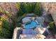 Aerial view of backyard featuring pool, cabana, spa, outdoor firepit, extensive landscaping, and patio at 2679 Wynnton Dr, Duluth, GA 30097