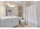 Bright bathroom featuring a white vanity, toilet, and bathtub with a decorative shower curtain at 2679 Wynnton Dr, Duluth, GA 30097