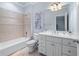 Elegant bathroom showcasing a tub with tile surround, commode, and vanity with ample storage at 2679 Wynnton Dr, Duluth, GA 30097