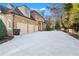 Long concrete driveway leading to a three-car garage of this brick home with well manicured bushes at 2679 Wynnton Dr, Duluth, GA 30097