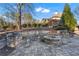 Stone fire pit with built-in seating area and decorative landscaping, creating a cozy outdoor gathering space at 2679 Wynnton Dr, Duluth, GA 30097