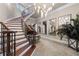 Grand foyer boasting a spiral staircase, elegant chandelier, and decorative mirrors at 2679 Wynnton Dr, Duluth, GA 30097