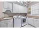 Functional laundry room with white cabinetry, sink, and modern washer/dryer at 2679 Wynnton Dr, Duluth, GA 30097