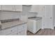 A close up of the kitchen showing white cabinets and granite countertops with hard surface flooring at 8656 Webb Rd, Riverdale, GA 30274