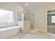 This bathroom features a freestanding tub, glass-enclosed shower, and tile flooring at 1496 Rocky River Dr, Lawrenceville, GA 30045