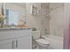 Well-lit bathroom featuring a tub with shower, a shelf, and a sink with vanity with a grey granite countertop at 1496 Rocky River Dr, Lawrenceville, GA 30045