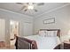 Cozy bedroom featuring a ceiling fan, neutral walls, and a bathroom nearby at 1496 Rocky River Dr, Lawrenceville, GA 30045