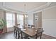 Elegant dining room features an expansive table set for eight and abundant natural light at 1496 Rocky River Dr, Lawrenceville, GA 30045