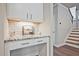 Hallway features custom wine rack with storage, granite countertop, and a stairway to upper level at 1496 Rocky River Dr, Lawrenceville, GA 30045