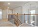 Hallway with carpet, wood and iron railings, and a decorative tray ceiling at 1496 Rocky River Dr, Lawrenceville, GA 30045