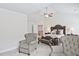 This main bedroom has neutral walls, two chairs, and a ceiling fan above the bed at 1496 Rocky River Dr, Lawrenceville, GA 30045