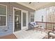 Covered porch offers a cozy outdoor seating area with a view to the home's interior through sliding doors at 1496 Rocky River Dr, Lawrenceville, GA 30045